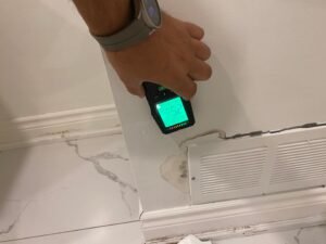 CPR24 Restoration technician using a moisture meter to inspect a water-damaged interior wall in Oakville.